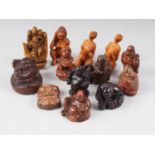 A carved hardwood netsuke, seated man with a fan, and ten other netsuke/okimono, various