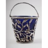 A Georgian silver swing-handled sugar basket with floral decoration and blue glass liner