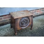 A carved oak box seat stool with mask design, on turned supports, 18" wide x 12" deep x 16" high