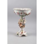 A German porcelain table centre with figure support and floral decoration, 16 inches high