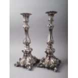 A pair of Continental embossed candlesticks, stamped 800, on scroll weighted bases, 15" high