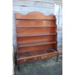 An early 19th century mahogany shaped back waterfall bookcase, fitted two drawers, on turned and