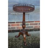 A walnut wine table with galleried top, on turned column and tripod splay support, 15" dia x 27 1/2"