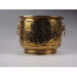 A hammered and embossed brass coal scuttle with coat of arms decoration, 14" wide x 11" high