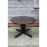 An Ercol dark oak finish circular extending dining table, on shaped panel splay support, 48" dia,