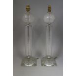 A pair of clear glass table lamps with engraved leaf decoration, on square bases, 21 12" high