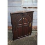 An 18th century oak corner hanging cupboard, fitted shaped shelves enclosed arch top panel door, 33"