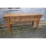 An antique Chinese carved elm "altar" table, fitted three drawers, on moulded supports, 74 1/2" wide