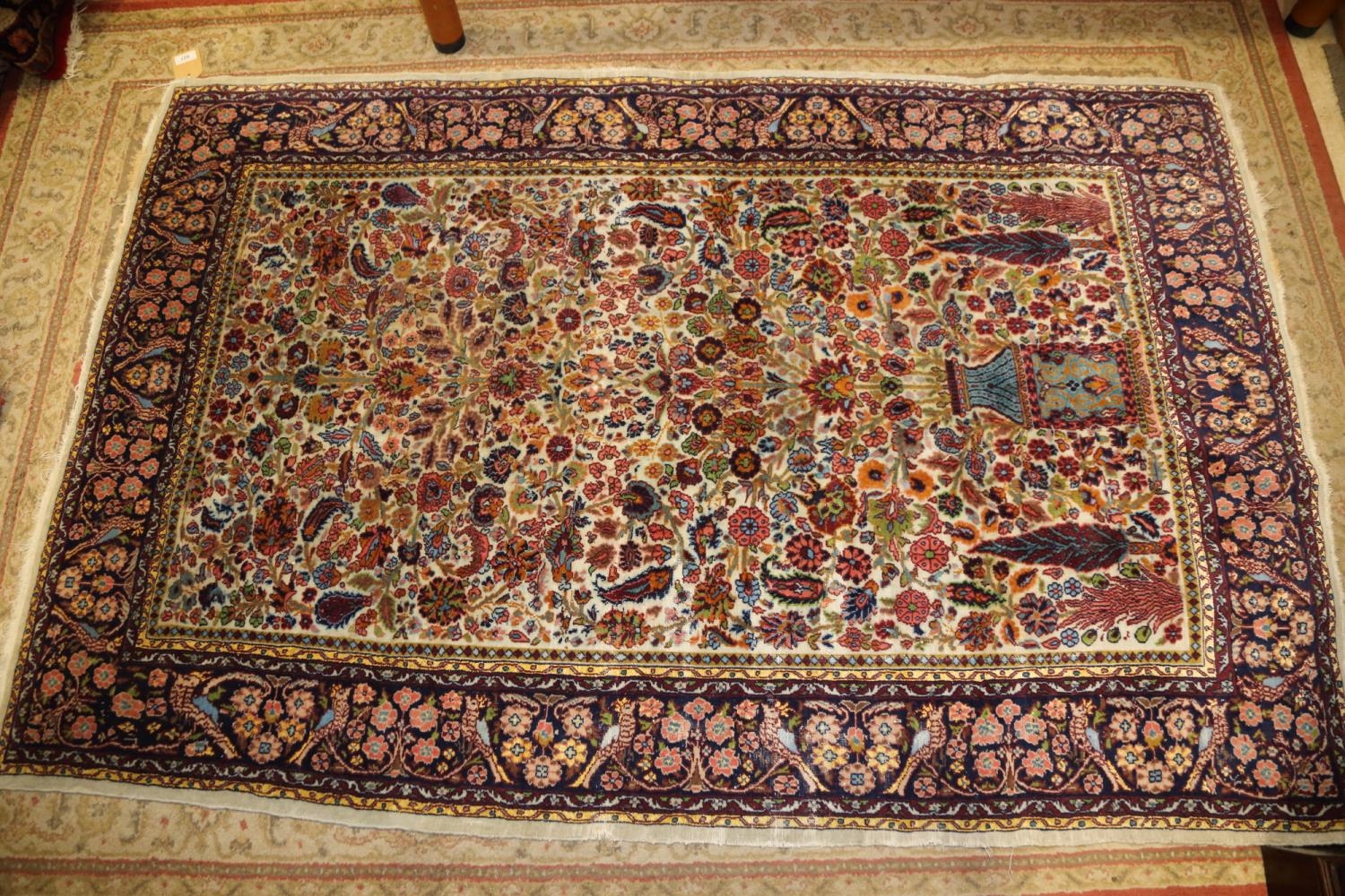 A Persian part silk pile tree and vase design rug on a light ground and multi-bordered in shades
