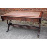 A mahogany sofa table/desk with leather inset top, fitted three drawers over lyre end supports