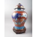 A Chinese cloisonne baluster vase and cover, decorated dragons and bats on a red ground, and