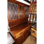 An oak dresser of 17th century design, the upper section fitted open shelves and leaded glazed panel