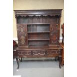 A 19th century oak dresser, the upper section fitted open shelves and cupboards enclosed panelled