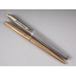 A Parker engine turned silver fountain pen with gold nib, and a similar rolled gold ballpoint pen