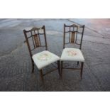 A pair of Edwardian line inlaid and marquetry splat back saloon chairs with floral needlework seats