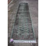 A Bokhara runner with sixty-two guls on a green ground 148" x 32"