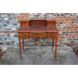 An Edwardian mahogany and satinwood banded break bowfront writing desk, fitted brass gallery over
