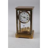 A 19th century brass and four glass mantel clock with white enamel dial and Roman numerals, 10" high