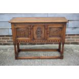 A carved oak side cupboard of 17th century design enclosed two panelled doors, on turned and