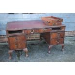 A mahogany double pedestal desk with tooled lined top, fitted seven drawers, on carved cabriole claw