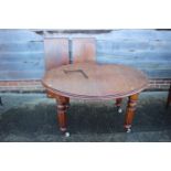 A 19th century mahogany wind out 'D' end dining table with two extra leaves, on turned, reeded and