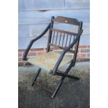 A late 19th century ebonised folding "campaign" chair with Turkey seat