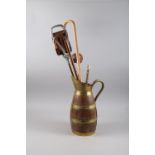 A brass coopered oak jug/stick stand, a number of walking sticks and a shillelagh