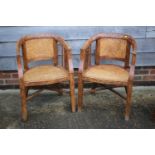 A pair of antique Chinese elm elbow chairs with woven seats and pierced splats, on square taper