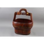 A Chinese hardwood and brass mounted bucket with carved handle, 18 1/4" high