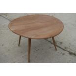 A 1960s Ercol light elm drop leaf dining table, on splay supports, 48" wide x 44 1/2" deep x 28 1/2"