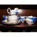 A Coalbrookdale type part tea and coffee service with landscape panels, on a blue and gilt scroll