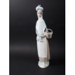 A Lladro figure of a girl with a basket of fruit, 14" high