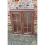 An early 20th century oak display cabinet enclosed leaded glazed doors, 28" wide x 7 1/2" deep x