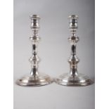 A pair of filled silver candlesticks, on circular bases, 8" high