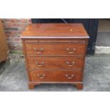 A bachelor's mahogany chest of three long graduated drawers with brushing slide over, on bracket