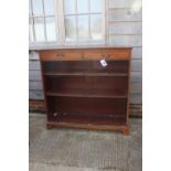 A Maples late 19th century walnut book case, fitted two drawers over open shelves, on bracket feet