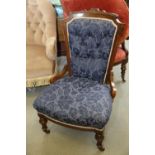 A late Victorian carved walnut showframe salon chair, button upholstered in a blue figured