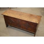 An early 18th century oak coffer with chip carved front and hinged lid, on panel end supports, 39"