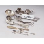 A quantity of silver plate, including a ladle, rattail spoons, three napkin rings, grape scissors