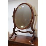A walnut oval swing frame toilet mirror, on skeleton stand, 17" wide x 24" high