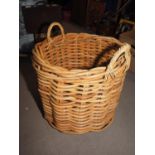 A woven bamboo log basket with carry handles, 24" dia