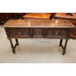 An antique carved oak dresser base, fitted three drawers, on turned and stretchered supports, 57"