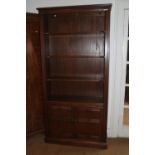 An Ercol elm bookcase, fitted two doors, on block base, 38" wide x 14" deep x 77" high, and a