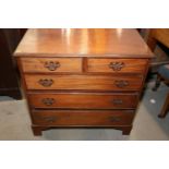 An Edwardian walnut chest of two short and three long graduated drawers with pierced brass handle