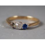 An 18ct gold and platinum three-stone dress ring, set central diamond and sapphire (one stone
