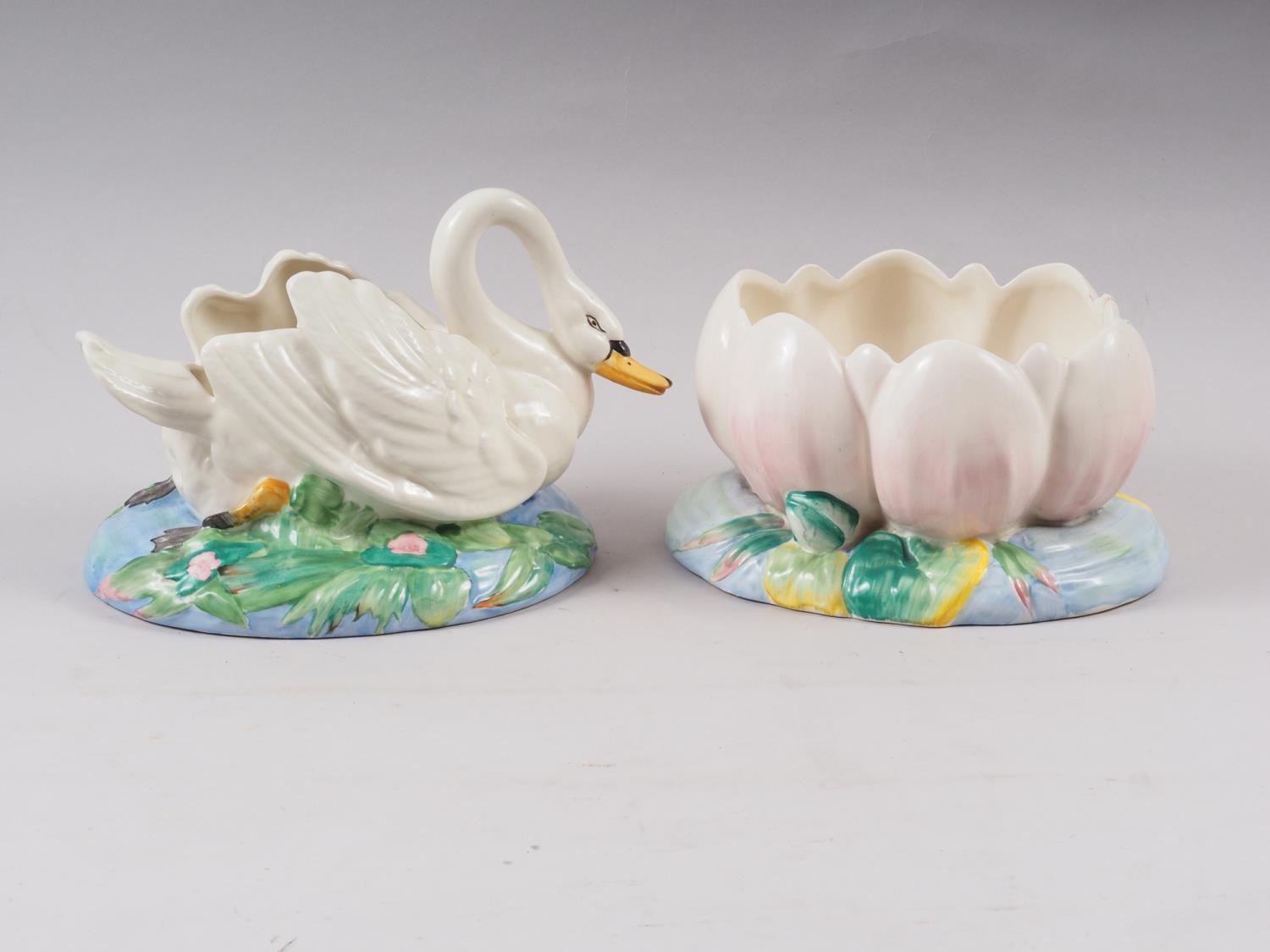 A Clarice Cliff table centre, formed as a swan, 7" high, and a companion table centre, formed as a