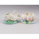 A Clarice Cliff table centre, formed as a swan, 7" high, and a companion table centre, formed as a