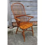 A high spindle back Windsor elbow chair, on turned and crinoline stretchered supports