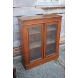 A 19th century walnut bookcase enclosed two glazed panel doors, on block base, 36" wide x 11" deep x