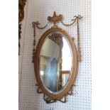 An Edwardian oval gilt framed wall mirror with vase and swag crest plate, 19 1/2" x 11 1/2"